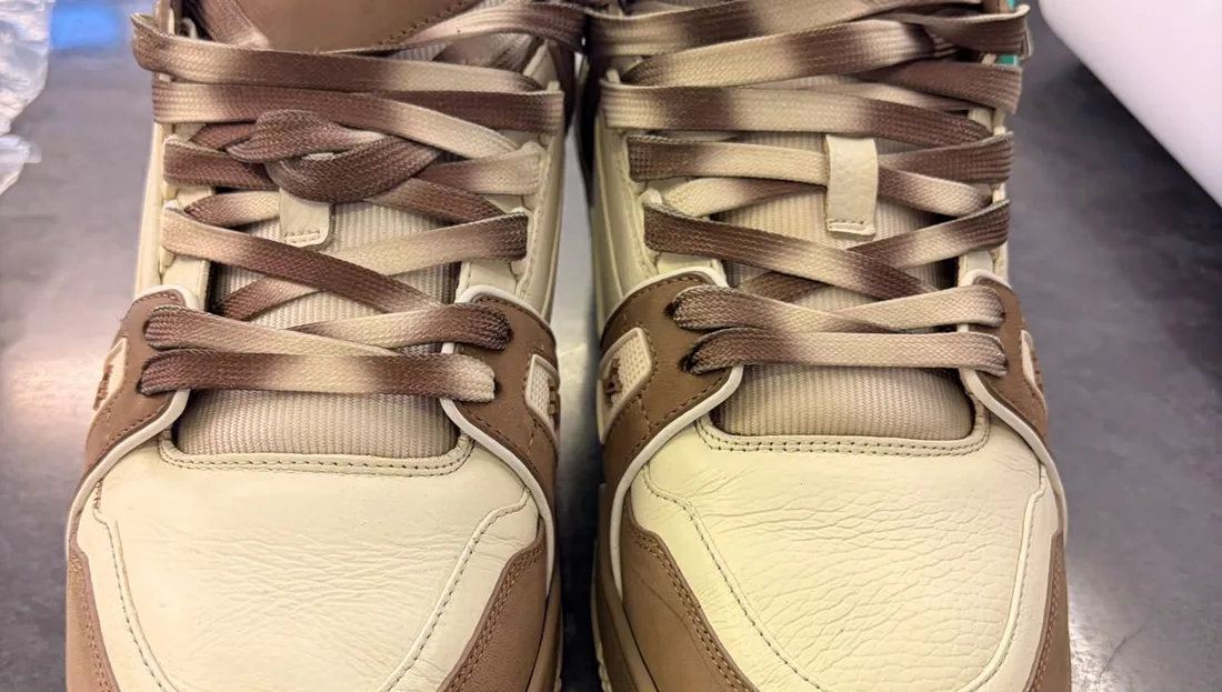 A pair of premium leather trainers cleaned and relaced on the counter